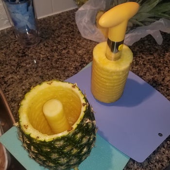 reviewer showing the inside of the pineapple with the insides taken out and wrapped around the corer