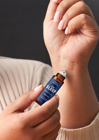Person applying This Works Deep Sleep indispensable  lipid  roll-on to wrist