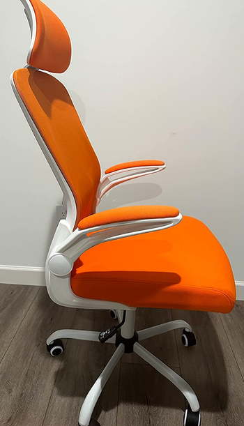 a reviewer photo of a profile view of the chair in orange 