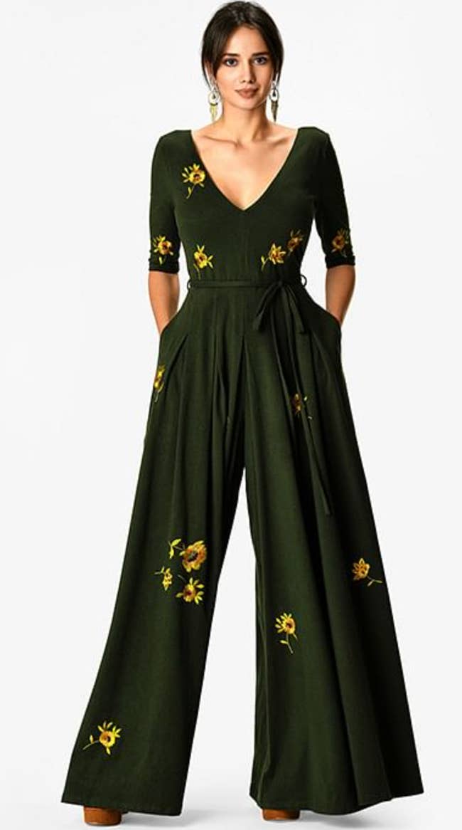 A model wearing a green jumpsuit with floral designs
