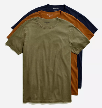 three garment-dyed T-shirts in different colors layered on top of one another