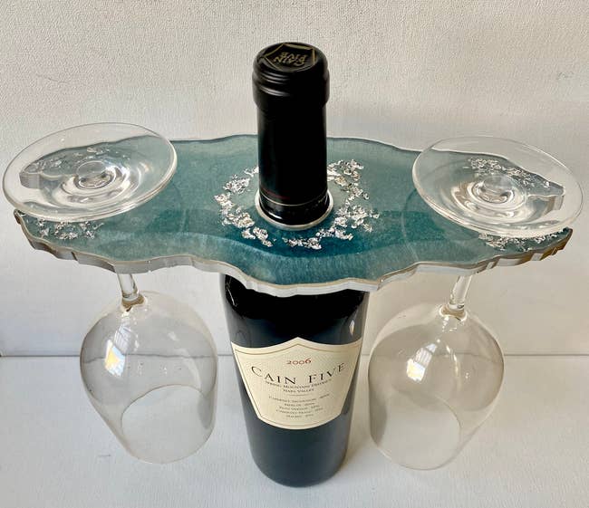 the steel blue geode resin wine butler holding a bottle of wine and two wine glasses