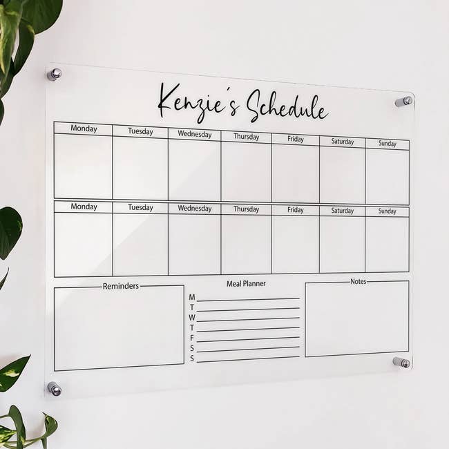 an acrylic wall calendar that has space to fill out a two-week schedule, reminder, meal planner, and notes