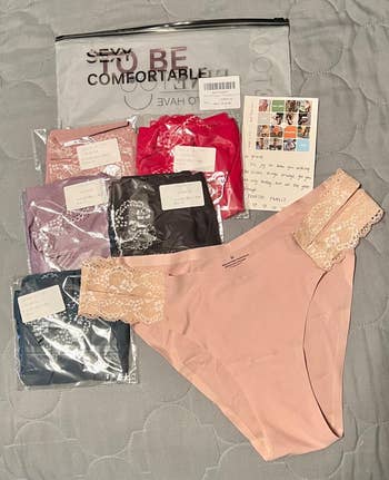 Assorted women's underwear with lace trims, packaging, and thank-you enactment placed connected a bedspread