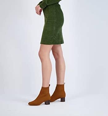 A model wearing the knit booties in brown