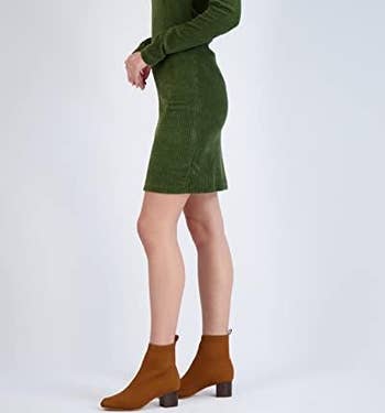 A model wearing the knit booties in brown