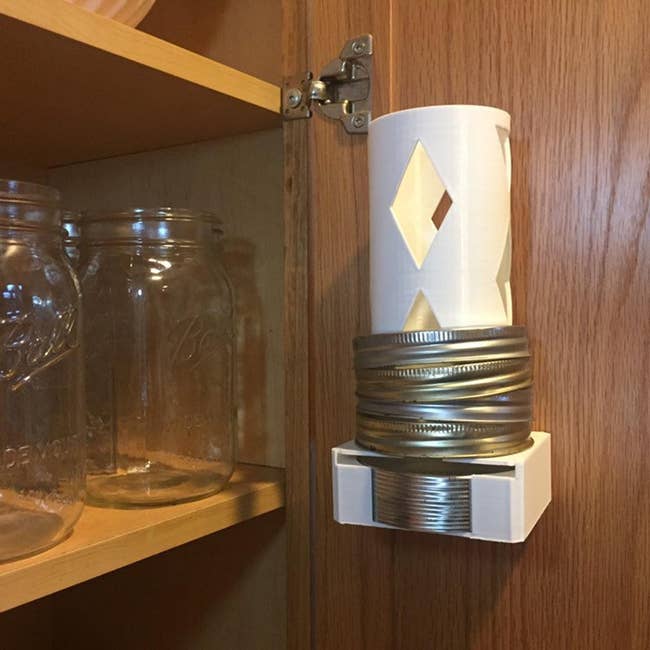 a white lid organizer mounted to a kitchen cabinet