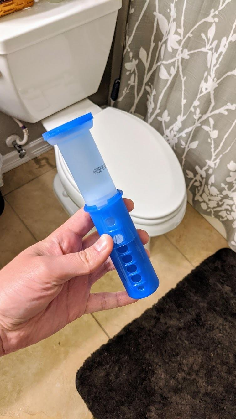 reviewer holding the Scrubbing Bubbles toilet gel stamp