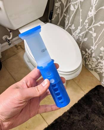 reviewer holding the Scrubbing Bubbles toilet gel stamp