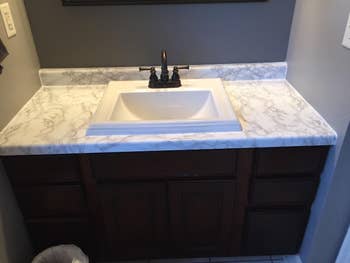 reviewer's same sink with white marble contact paper on it
