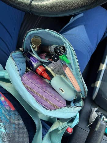Reviewer opened blue fanny pack to reveal lots of rooms for trinkets and gadgets 