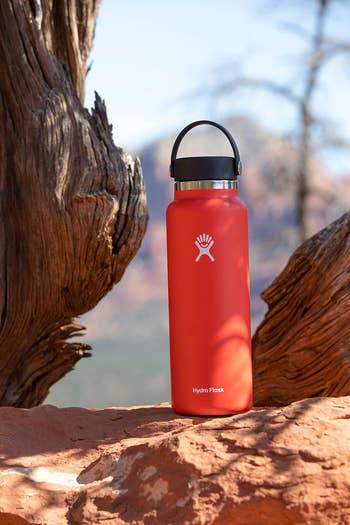 red hydro flask sitting on a rock