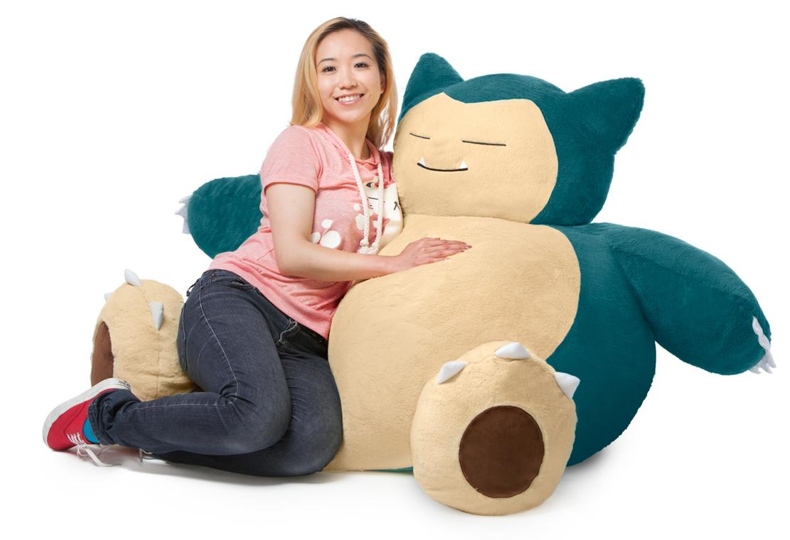 a model curled up with the massive snorlax beanbag