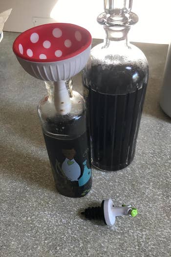 reviewer using mushroom funnel to refill bottle