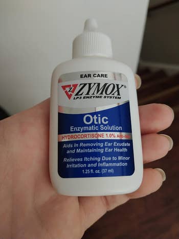 image of hand holding bottle of the ear treatment