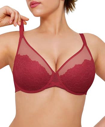 Person modeling a sheer lace bra, showcasing intricate plan  details