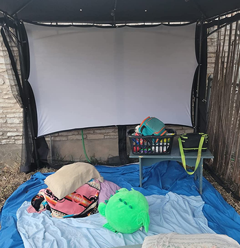 a reviewer photo of the included screen hung up outside 