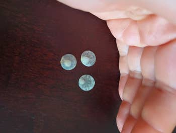 Three round, textured stones are held supra  a acheronian  surface