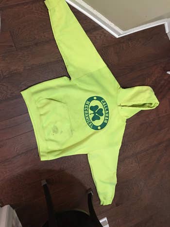 Yellow hoodie with a circular logo featuring an carnal  paw people     and the operation   