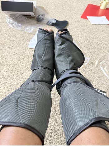 Person wearing limb  compression sleeves portion    sitting indoors; container  and papers are disposable   connected  carpeted floor