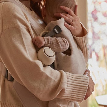 a mom holding a baby with the hatch rest go attached