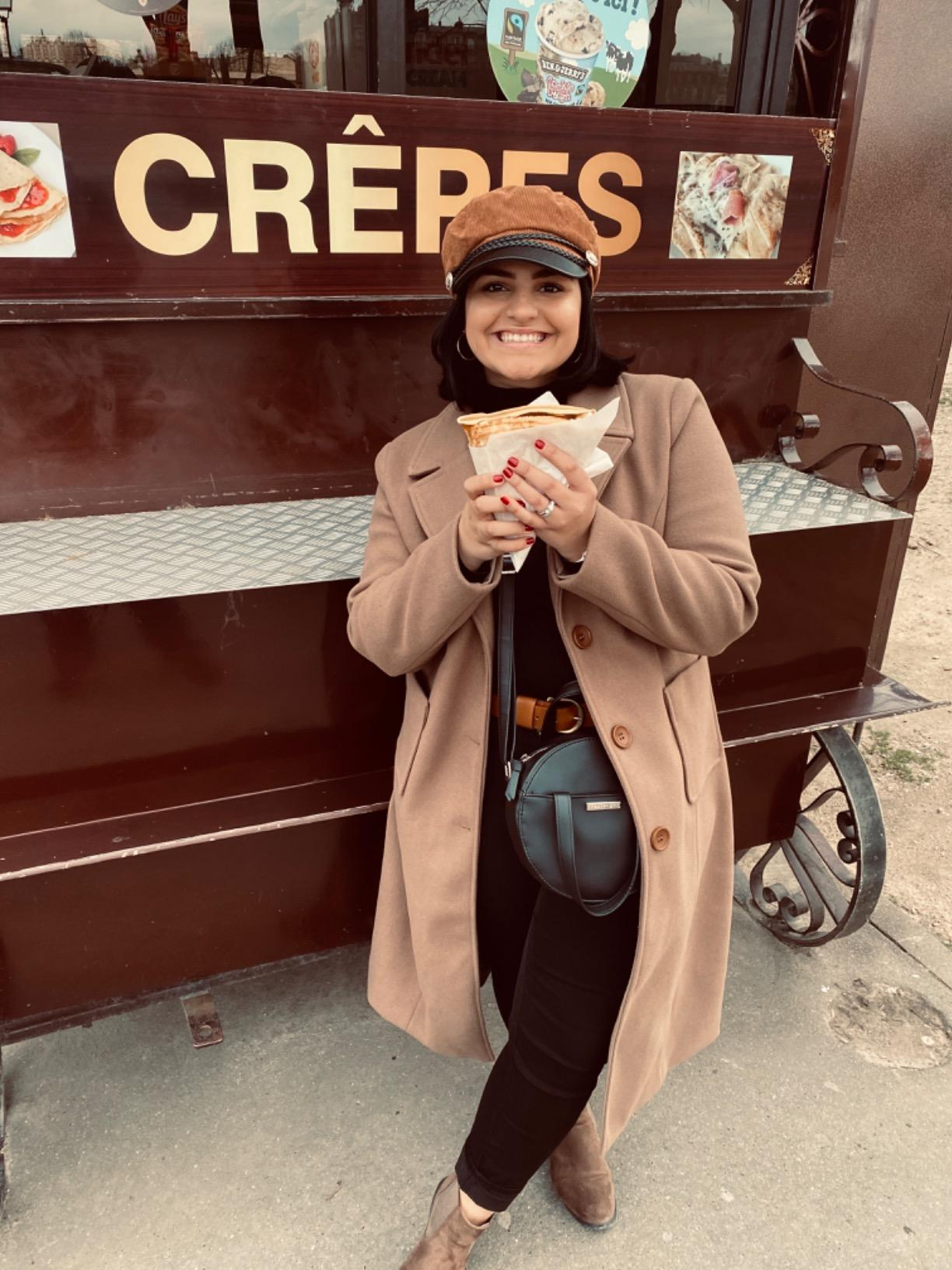 reviewer wearing the long coat in tan with a hat and brown boots