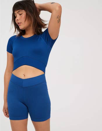 Model posing in a blue crop top and matching shorts set, suitable for activewear or casual summer outfits