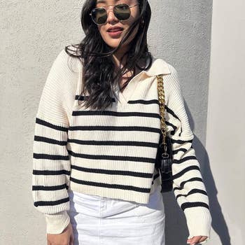 reviewer wearing the pullover in a cream and black striped pattern