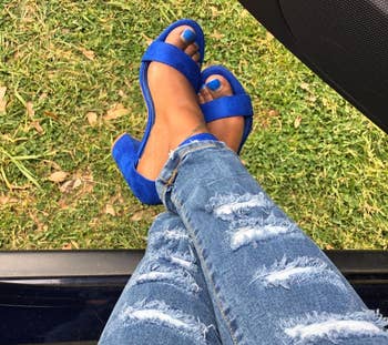 reviewer's feet wearing the blue heels