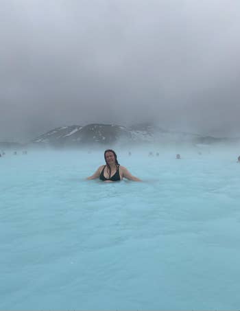 writer in water of The Blue Lagoon in Iceland with clouds and overcast weather