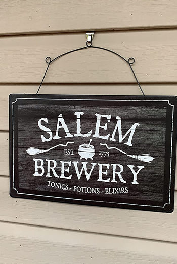 a reviewer photo of a sign hung up on the hook 