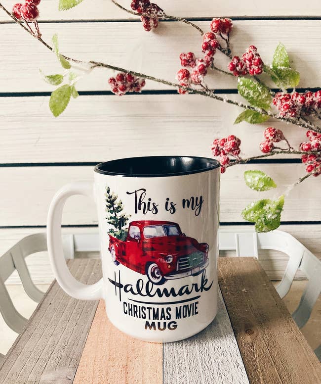 hand holding mug with pickup truck and christmas tree on it 