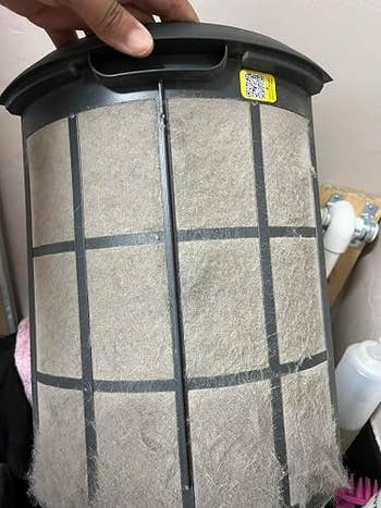 Hand holds a vacuum filter covered successful  particulate  and lint, illustrating the request   for cleaning oregon  replacement erstwhile   maintaining location  appliances