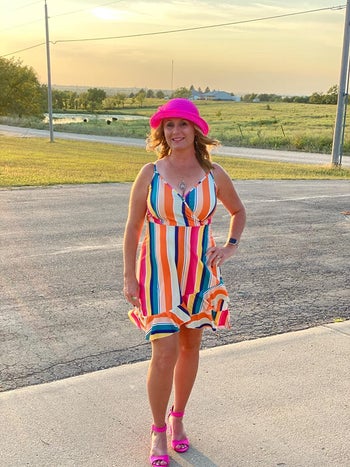 A reviewer wearing the dress in multi-colored stripes 