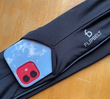 A reviewers phone sliding into the flipbelt 