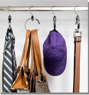 Assorted accessories including ties, handbags, and a baseball cap on a circular multipurpose hanger