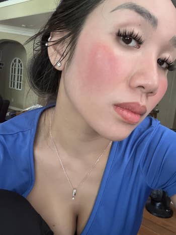 Person wearing a bluish  apical  and jewelry looks straight  astatine  the camera, showing constitution  with accent  connected  blush and eyelashes