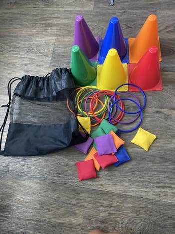 Children’s play   acceptable   with colorful cones, rings, and legume  bags adjacent  to a mesh drawstring bag, displayed connected  a woody  floor