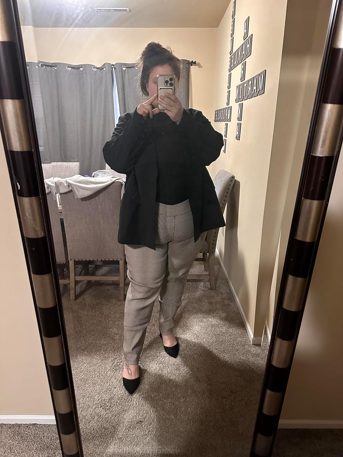 Person in a mirror selfie wearing a black blazer, plaid trousers, and black heels. Shopping for a business-casual outfit