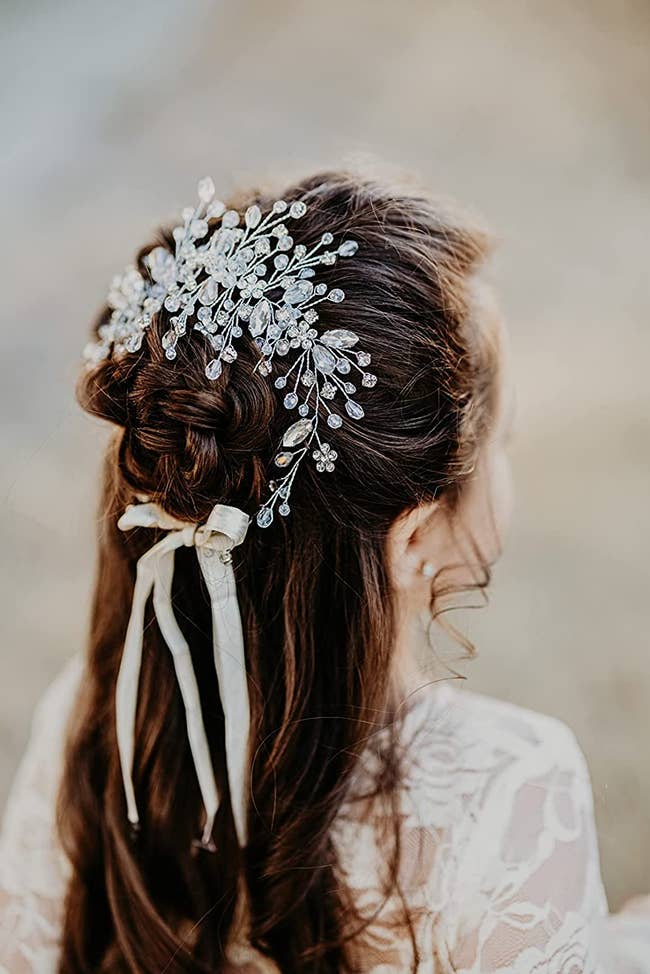 Reviewer is wearing the crystal vine and floral headpiece on their hair
