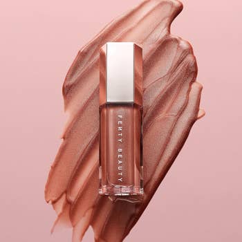 Fenty Beauty lipstick with creamy texture smeared in the background, showcasing the product for shopping purposes