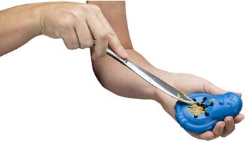 Person utilizing a serrated weapon to dispersed peanut food connected a bluish integrative sandwich-shaped gadget