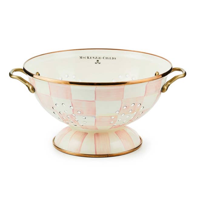 Mackenzie-Childs colander with pinkish  checkered signifier   and brass handles, suitable for stylish room  use