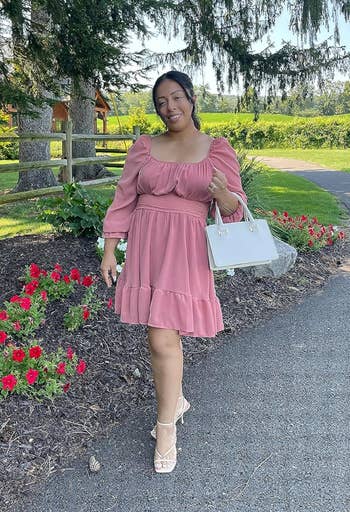 a reviewer wearing the dress in a pink color