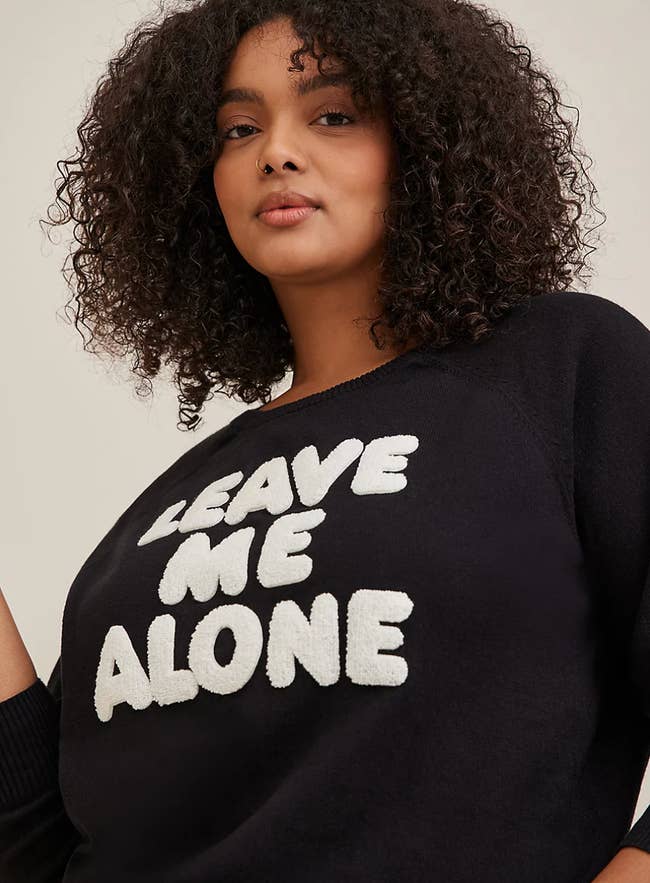 model wearing black sweater that says 