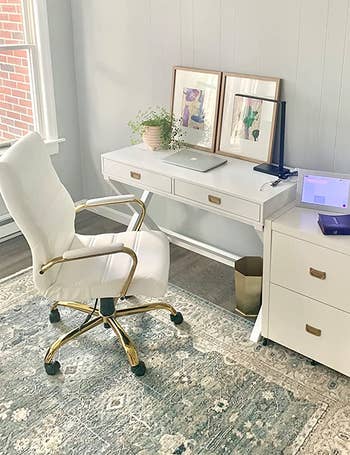 a reviewer photo of the same chair in white in front of a desk