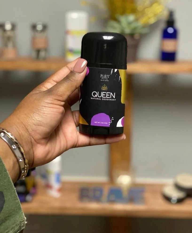 model holding black Queen deodorant