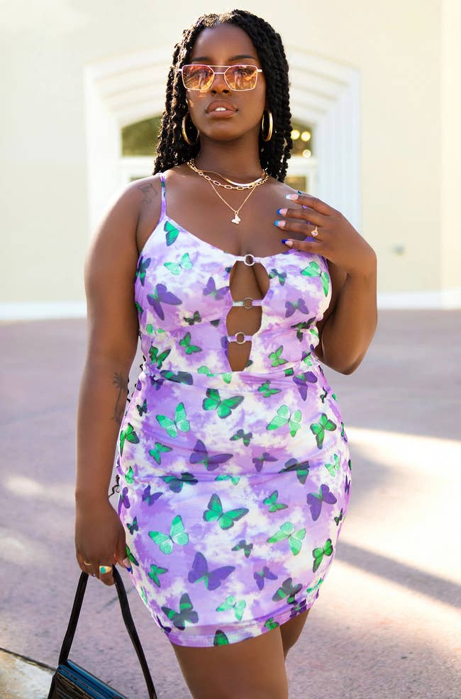 model in strapless green and purple butterfly-print mini cutout dress with slip underneath