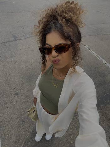reviewer posing for selfie wearing brown sunglasses