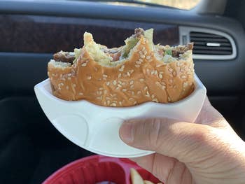 the same reviewer showing how easy it is to eat the burger using the holder
